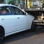 White car rear-ended by tow truck.