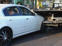 White car rear-ended by tow truck.