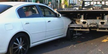 White car rear-ended by tow truck.