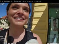 Woman smiling outdoors with sunny background in Prague.