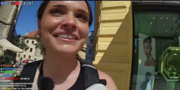 Woman smiling outdoors with sunny background in Prague.