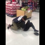 Security tackle in supermarket near bottled drinks display.