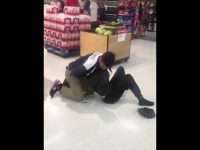 Security tackle in supermarket near bottled drinks display.