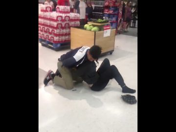 Security tackle in supermarket near bottled drinks display.