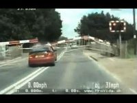 Car crossing railway tracks under lowering barriers.
