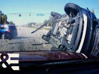 Two-car collision at intersection with flipped vehicle.