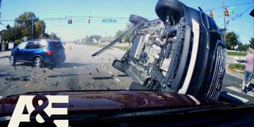 Two-car collision at intersection with flipped vehicle.