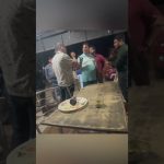 Group of men arguing near a table at night.
