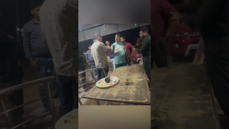 Group of men arguing near a table at night.