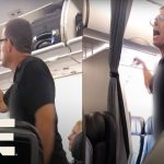 Passenger arguing on airplane near luggage compartment.