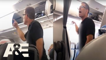 Passenger arguing on airplane near luggage compartment.
