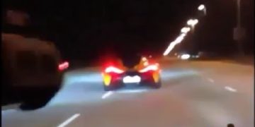 Sports car driving fast on highway at night.