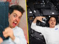 Man holding keyboard, lying on pile of keyboards