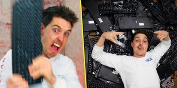 Man holding keyboard, lying on pile of keyboards
