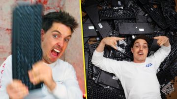 Man holding keyboard, lying on pile of keyboards