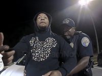 Police officer detaining a person at night.
