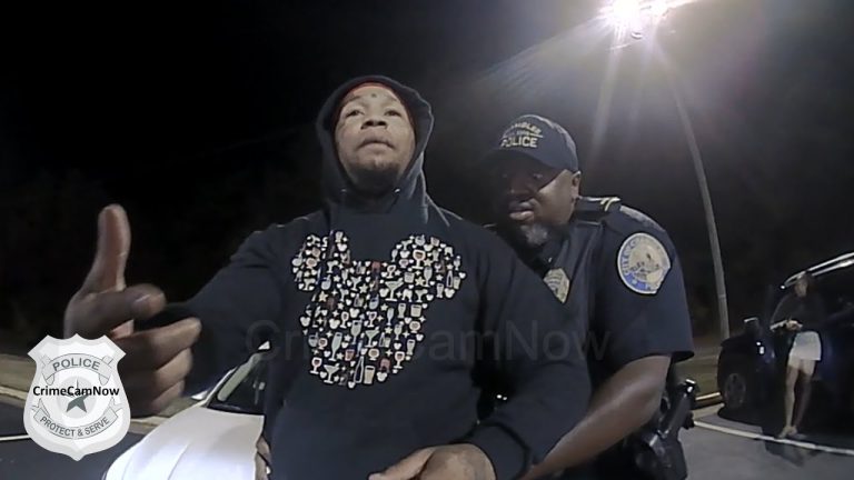 Police officer detaining a person at night.
