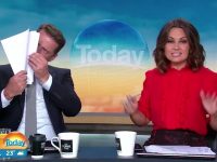 TV hosts on morning show, one reading papers.