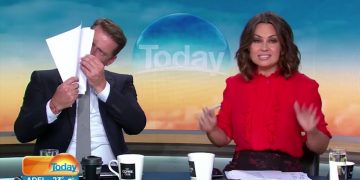 TV hosts on morning show, one reading papers.