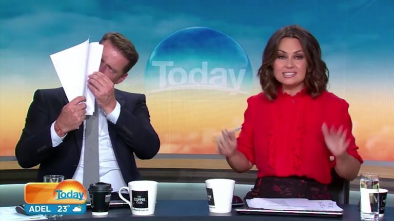 TV hosts on morning show, one reading papers.