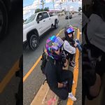 Motorcyclists resting with helmets on road median.