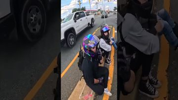 Motorcyclists resting with helmets on road median.