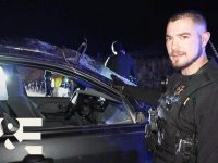 Officer investigates vehicle at night scene.