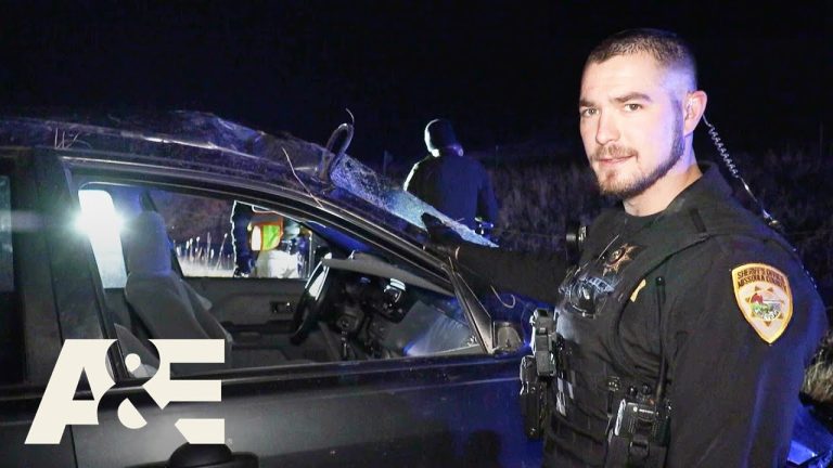 Officer investigates vehicle at night scene.