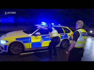 Police officers respond with patrol car at night.