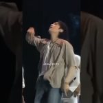Person performing energetically on stage with microphone.