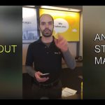 Store manager at counter, gesturing during conversation.