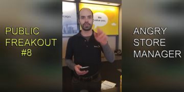 Store manager at counter, gesturing during conversation.
