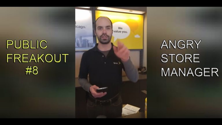 Store manager at counter, gesturing during conversation.