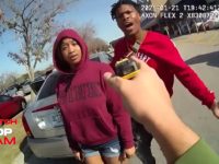 Police interaction with two individuals in parking lot.