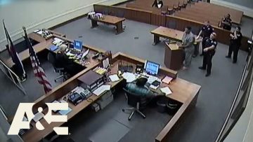 Courtroom scene with officials and a defendant.