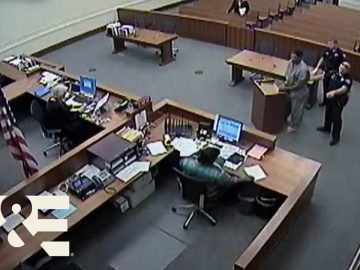 Courtroom scene with officials and a defendant.