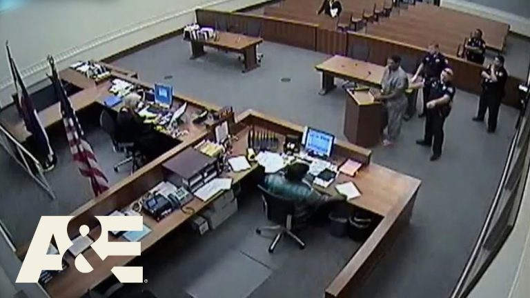 Courtroom scene with officials and a defendant.