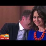 TV news anchors smiling during broadcast