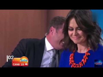 TV news anchors smiling during broadcast