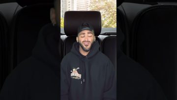 Person smiling in a car with hoodie