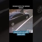 Black car on roadside, open door, traffic caution.