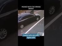 Black car on roadside, open door, traffic caution.