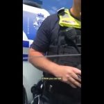 Police officer standing near vehicle.
