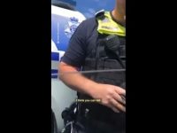 Police officer standing near vehicle.