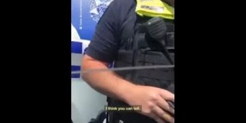 Police officer standing near vehicle.