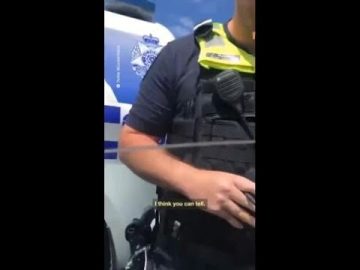 Police officer standing near vehicle.