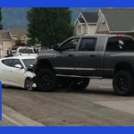 SUV on car after accident in residential area.