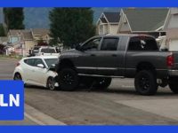 SUV on car after accident in residential area.