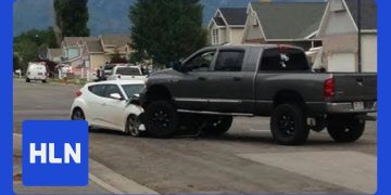SUV on car after accident in residential area.