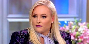 Person with blonde hair on a talk show set.